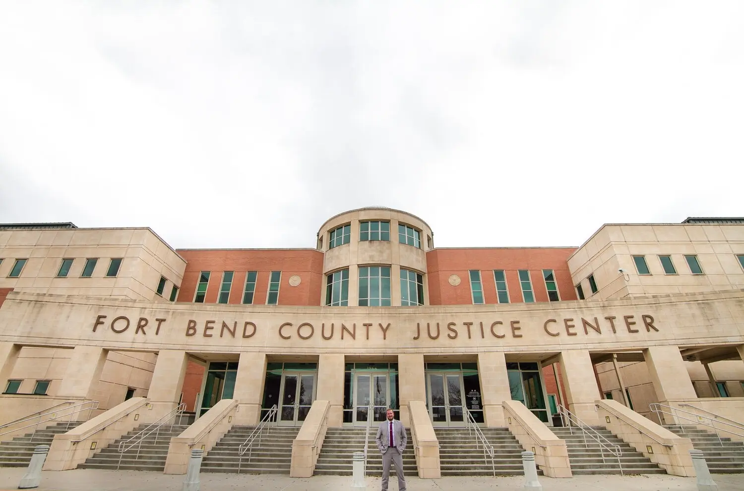 Personal Injury Lawyer Benjamin Brushe standing in front of the Fort Bend County Justice Center